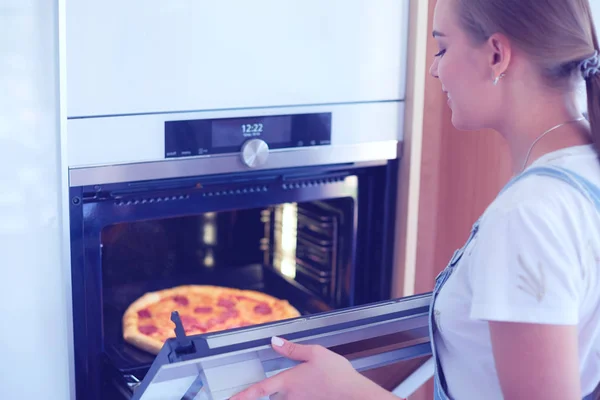 Jovem feliz cozinhar pizza em casa — Fotografia de Stock