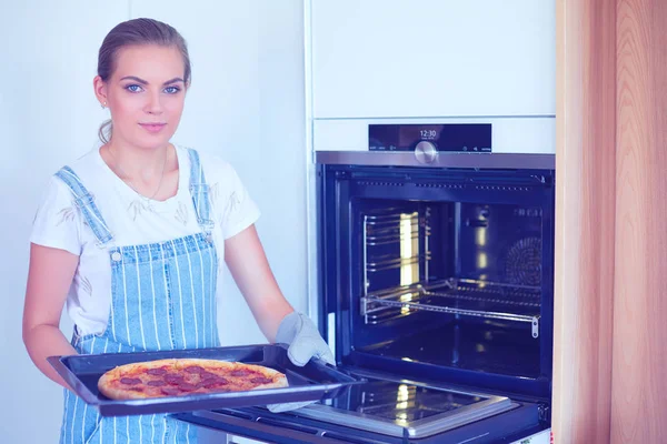 Gelukkig jong vrouw koken pizza thuis — Stockfoto