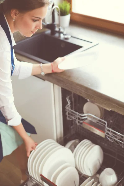 Lavavajillas. Mujer joven en la cocina haciendo tareas domésticas. Lavado. — Foto de Stock