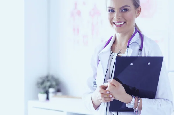 Usmívající se doktorka se složkou v uniformě stojící — Stock fotografie