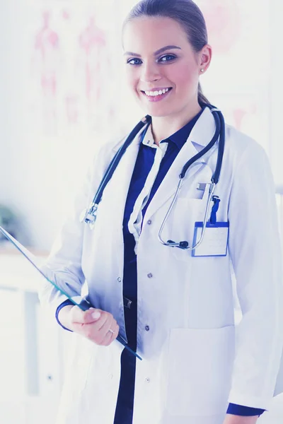 Médecin souriante avec un dossier en uniforme debout — Photo