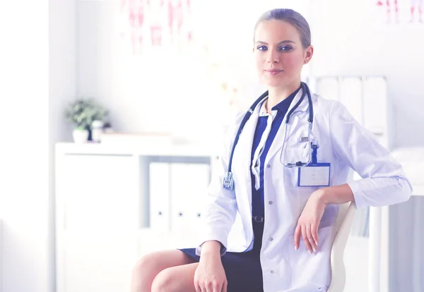 Retrato de uma jovem médica sentada à mesa no hospital — Fotografia de Stock