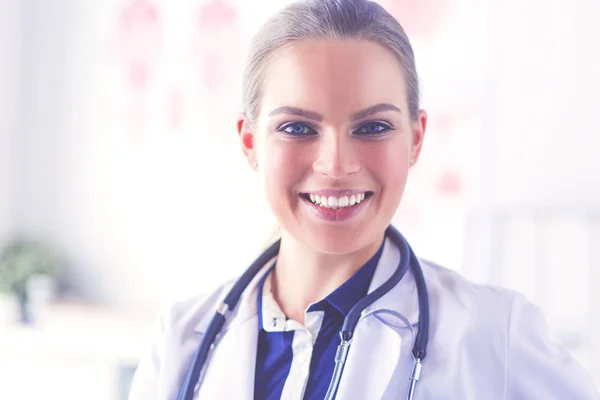 Portrait of young female doctor sitting at desk in hospital — Stock Photo, Image