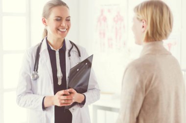 Doktor ve hasta masada otururken bir şey tartışıyorlar. İlaç ve sağlık hizmetleri kavramı