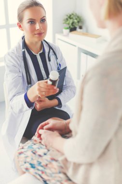 Doktor ve hasta masada otururken bir şey tartışıyorlar. İlaç ve sağlık hizmetleri kavramı