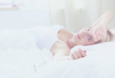 Güzel bir kadın yatağında uzanıyor.