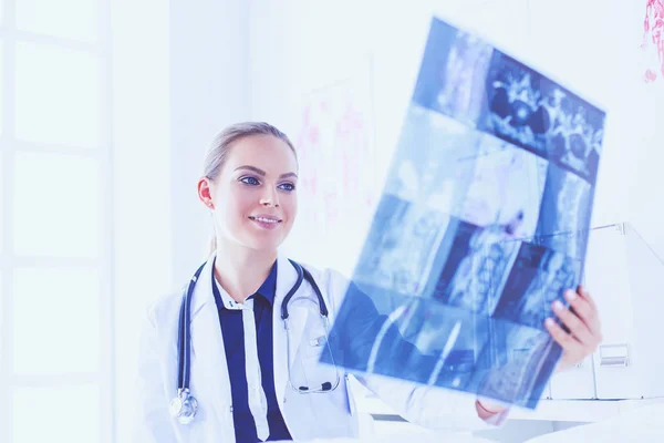 Young attractive female doctor looking at x-ray image — Stock Photo, Image