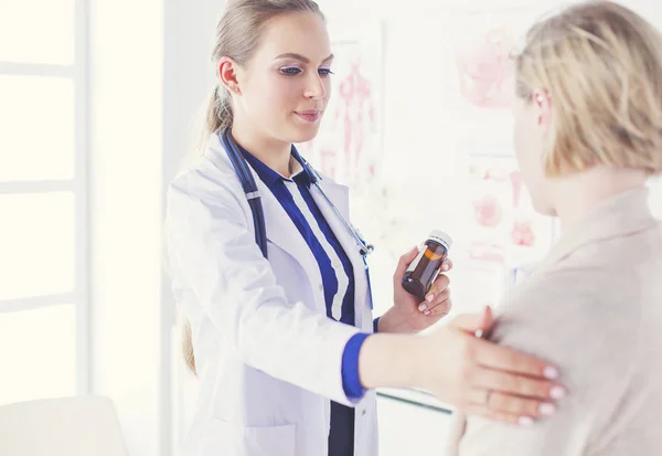 Arzt und Patient diskutieren etwas, während sie am Tisch sitzen. Medizin und Gesundheitskonzept — Stockfoto