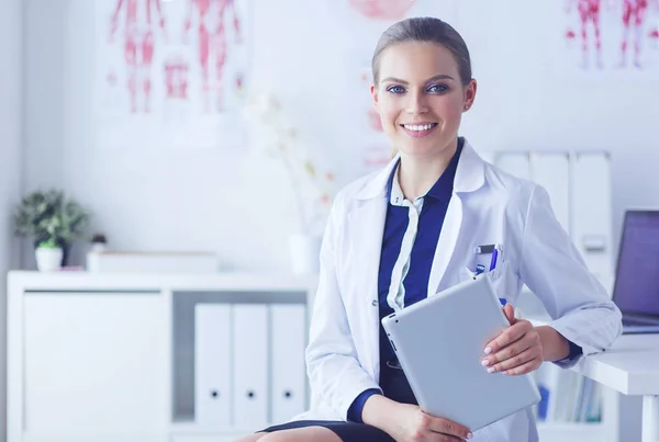 Ritratto di donna medico nel corridoio dell'ospedale, con in mano un tablet, che guarda la macchina fotografica, sorride — Foto Stock