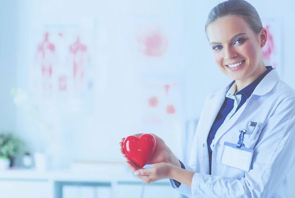 Mujer Joven Doctora Sosteniendo Corazón Rojo Pie Sobre Fondo Del — Foto de Stock