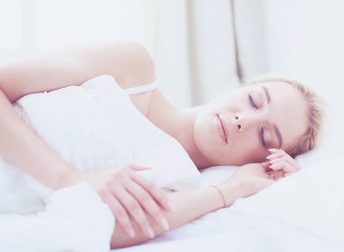 Güzel bir kadın yatağında uzanıyor.