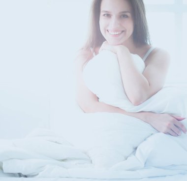 Yatağında evde oturan güzel kadın