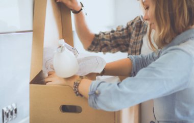 Genç bir çift yeni evde büyük karton kutu taşıyan. Ev taşıma. Genç Çift