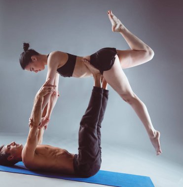 Genç çift Acro yoga mat Studio birlikte uygulamak. Acroyoga. Çift yoga. Ortak yoga.