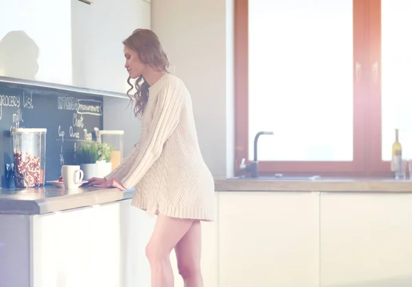 Jovem mulher de pé na cozinha. — Fotografia de Stock