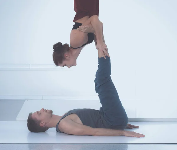 Jovem casal atlético praticando acroioga. Balanceamento em par . — Fotografia de Stock