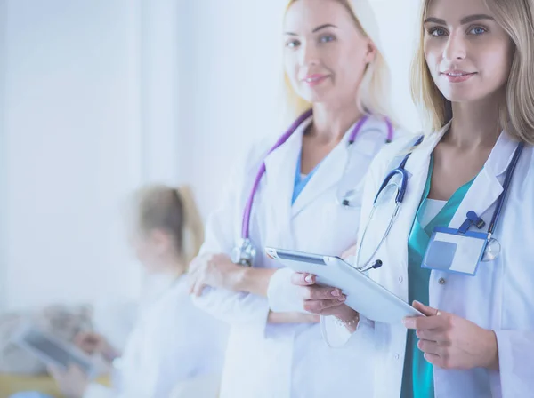 Retrato de tres doctores confiados de pie con los brazos cruzados en el consultorio médico — Foto de Stock