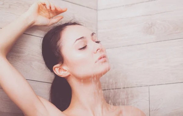 Junge schöne Frau unter der Dusche im Badezimmer. — Stockfoto