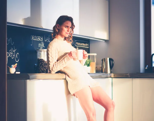 Молодая женщина стоит на кухне . — стоковое фото