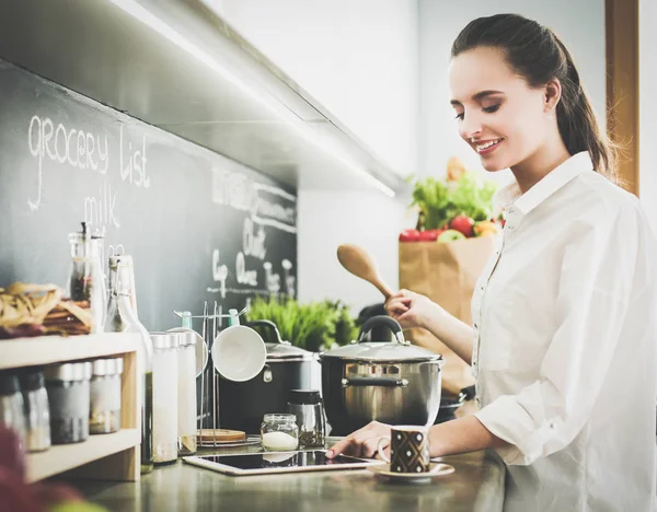 Mujer joven tableta en la cocina. — Foto de Stock