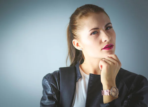 Portrait of beautiful young brunette woman in stylish black jacket on gray. — Stock Photo, Image