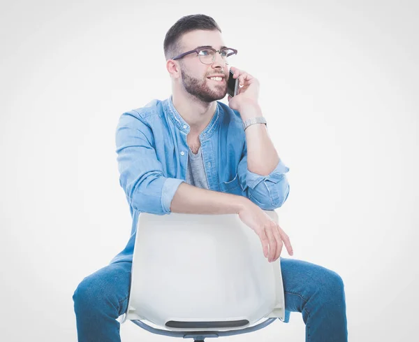 Giovane seduto sulla sedia e utilizzando il telefono cellulare. Startupper. Giovane imprenditore . — Foto Stock