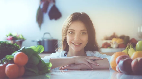 Junge Frau steht neben Schreibtisch in der Küche — Stockfoto