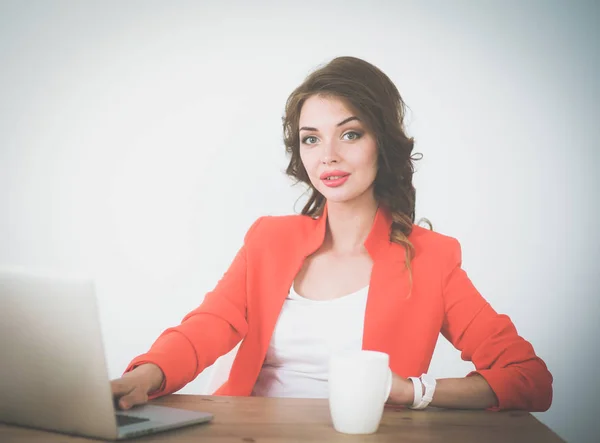 Mulher atraente sentada na mesa no escritório, trabalhando com computador portátil — Fotografia de Stock