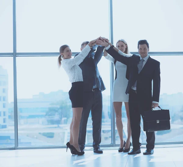 Бизнес-команда объединяет усилия стоя в офисе — стоковое фото