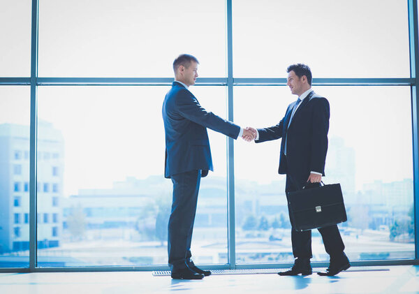 Изображение двух успешных бизнесменов, пожимающих друг другу руки