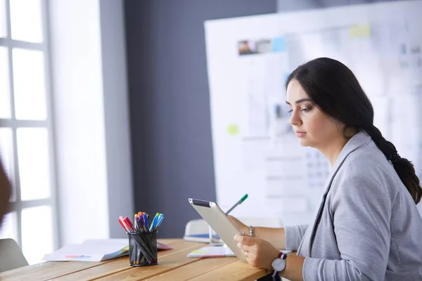 Досить молода жінка-менеджер, використовуючи сучасний цифровий планшет в офісі . — стокове фото