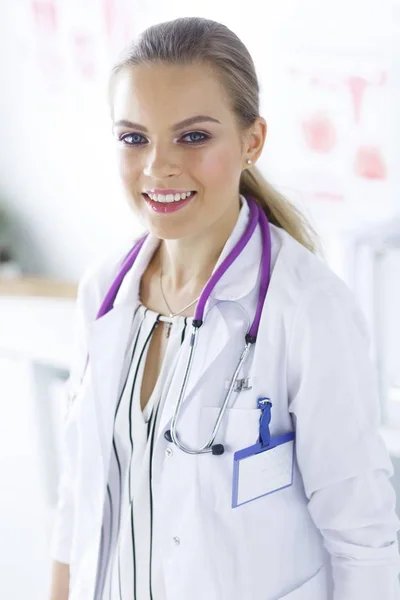 Médico sonriente con un estetoscopio médico de pie uniforme — Foto de Stock