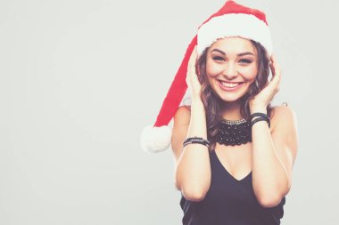 gülümseyen bir Noel Baba şapkası giyen güzel bir kadın portresi.