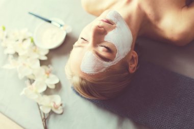 Yüz maskesi. Güzel genç kız Spa, makyajcısı kadın yüz maskesi uygulama.