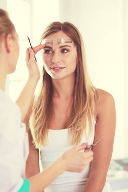 Kaşlar için kalıcı makyaj. Güzellik salonunda kalın kaşlı güzel bir kadın..