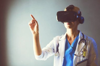 Sanal gerçeklik gözlüğü takan kadın doktor beyaz arka planda izole edilmiş..