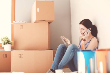 Kadın seçerek boya rengi renk örneği yeni ev ahşap yere oturmak için. Kadın evde