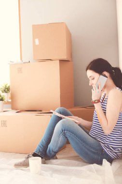 Kadın seçerek boya rengi renk örneği yeni ev ahşap yere oturmak için. Kadın evde