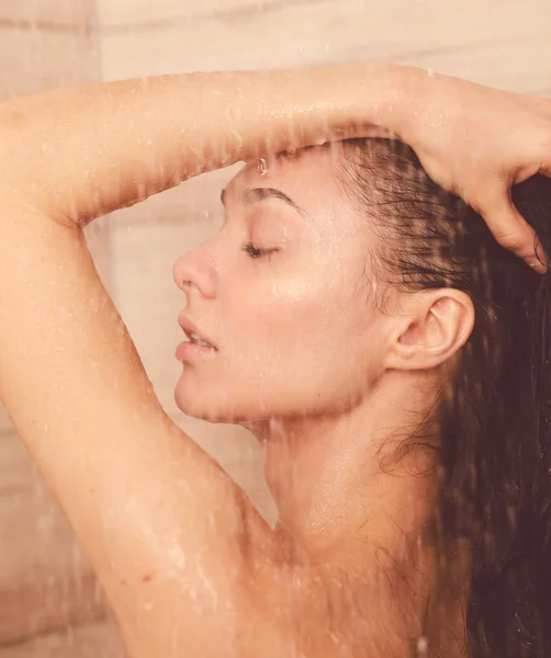 Junge schöne Frau unter der Dusche im Badezimmer. — Stockfoto