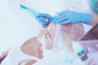 Kaşlar için kalıcı makyaj. Güzellik salonunda kalın kaşlı güzel bir kadın..