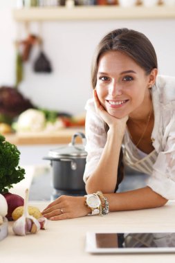 Mutfakta ipad 'ini kullanan genç bir kadın. Genç kadın.