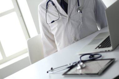 Tıbbi ekipman: Beyaz arka planda mavi steteskop ve tablet. Tıbbi ekipman