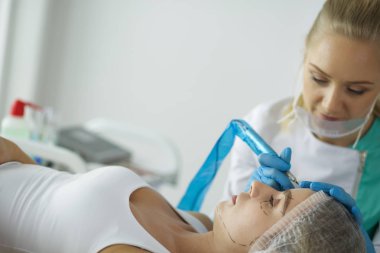 Kaşlar için kalıcı makyaj. Güzellik salonunda kalın kaşlı güzel bir kadın..