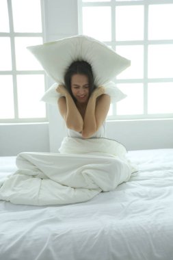 Onun baş ve kulaklar yastık ile kapsayan genç Kafkas kadın.