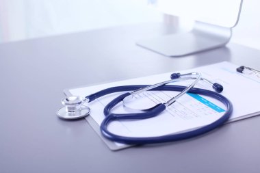 Tıbbi ekipman: Beyaz arka planda mavi steteskop ve tablet. Tıbbi ekipman