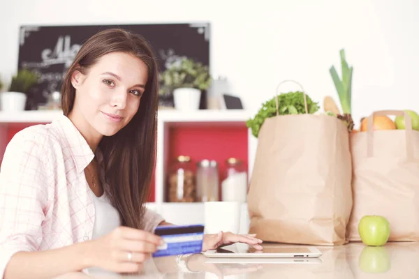 Young woman in the kitchen, using her ipad. Young woman — Stock Photo, Image