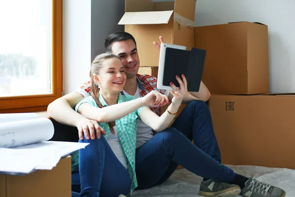 Casal movendo-se em casa sentado no chão com ipad. Casal. — Fotografia de Stock