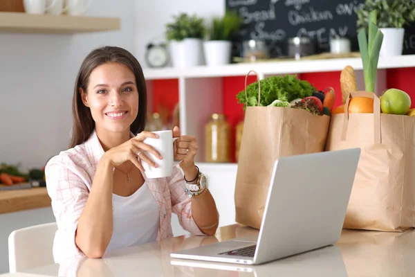 Mujer sonriente compras en línea utilizando tableta y tarjeta de crédito en la cocina. Mujer sonriente —  Fotos de Stock