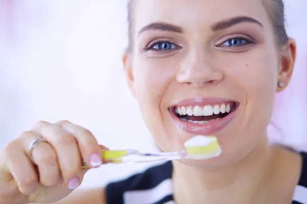 Joven chica bonita manteniendo la higiene bucal con cepillo de dientes . — Foto de Stock