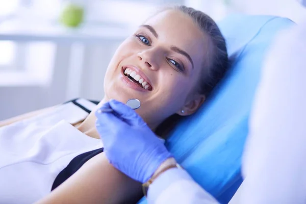 Joven paciente femenina con sonrisa bonita examinando la inspección dental en el consultorio del dentista. — Foto de Stock